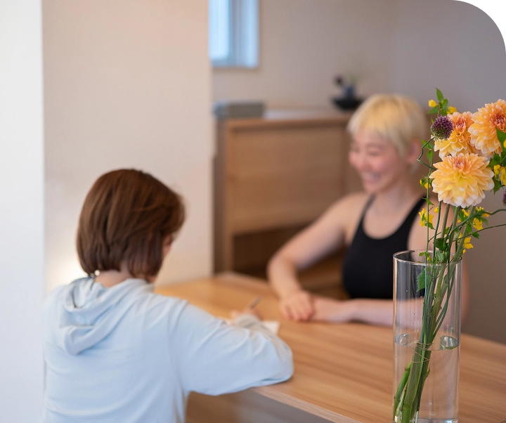 向き合うピラティスインストラクターとクライアントの女性